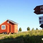 A vibrant and inviting scene depicting a tiny house parked on a picturesque piece of personal land